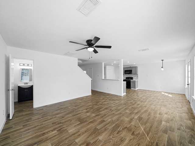 unfurnished living room featuring dark hardwood / wood-style floors, ceiling fan, and a wealth of natural light