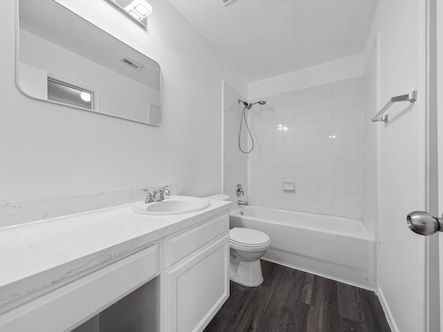 full bathroom featuring tiled shower / bath, vanity, hardwood / wood-style floors, and toilet