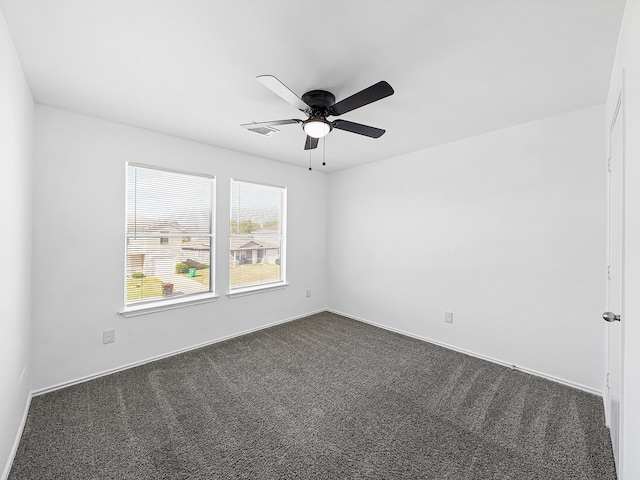 empty room featuring dark carpet and ceiling fan