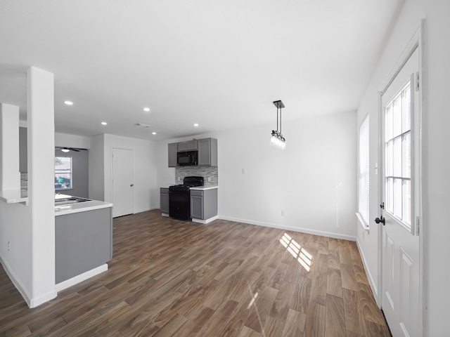 unfurnished living room featuring ceiling fan and dark hardwood / wood-style floors