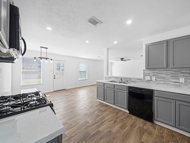 kitchen with black dishwasher, backsplash, dark wood-type flooring, gray cabinetry, and sink