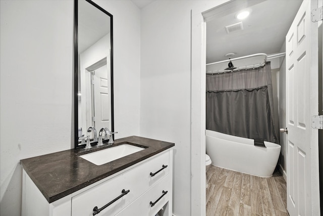 full bathroom featuring vanity, toilet, separate shower and tub, and hardwood / wood-style floors