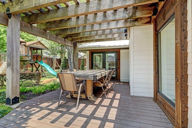 view of patio featuring a playground, a wooden deck, and a pergola