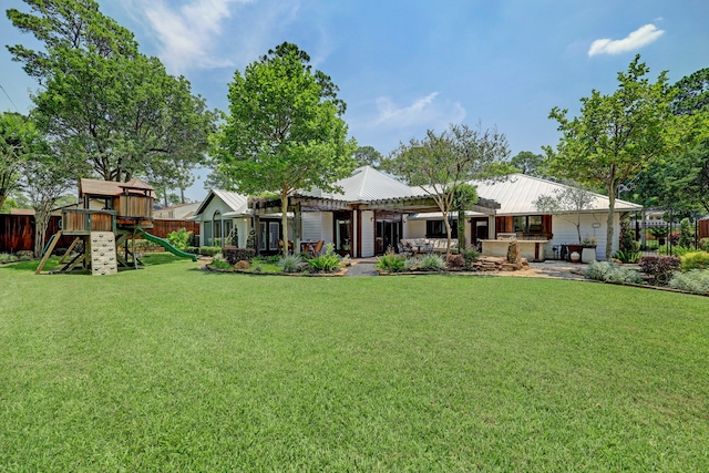 rear view of property with a lawn and a playground