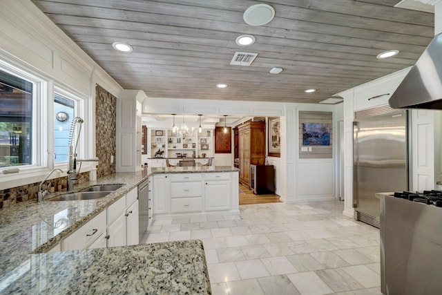 kitchen featuring hanging light fixtures, sink, light stone countertops, white cabinetry, and appliances with stainless steel finishes