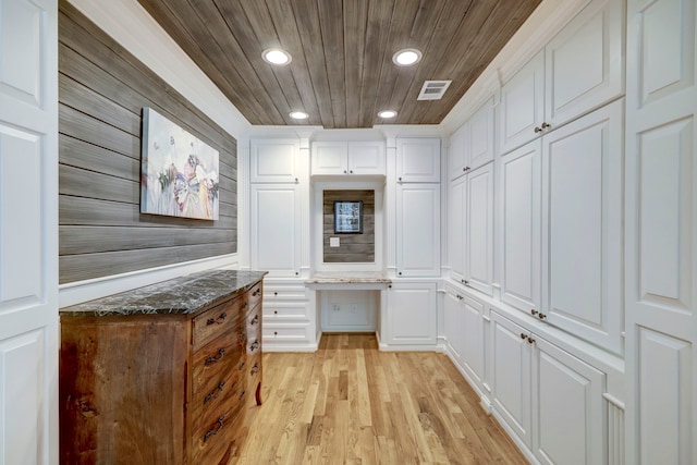 interior space with built in desk, wood ceiling, and light hardwood / wood-style flooring