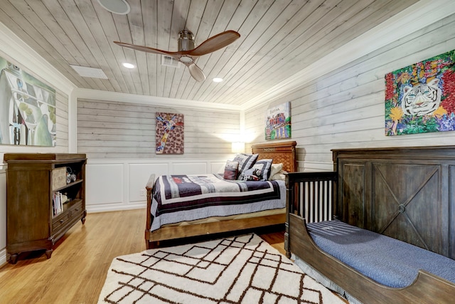 bedroom featuring wood ceiling, light hardwood / wood-style flooring, wooden walls, and ceiling fan