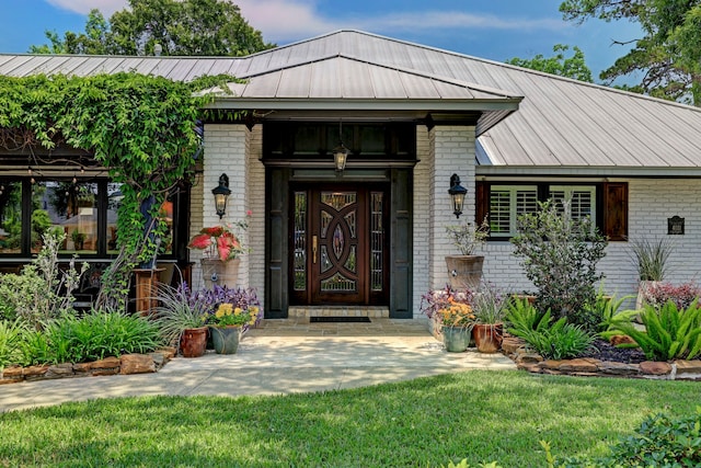 view of exterior entry with a yard