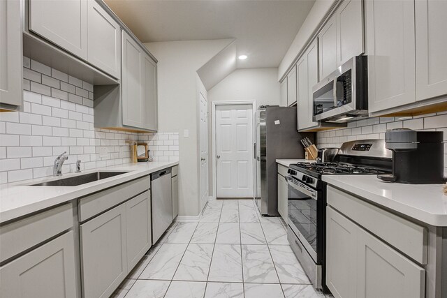 kitchen with gray cabinets, sink, stainless steel appliances, and tasteful backsplash