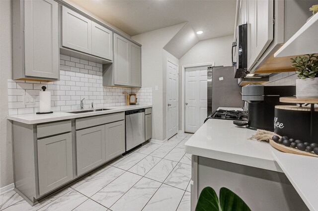 kitchen featuring sink, gray cabinetry, stainless steel appliances, and tasteful backsplash