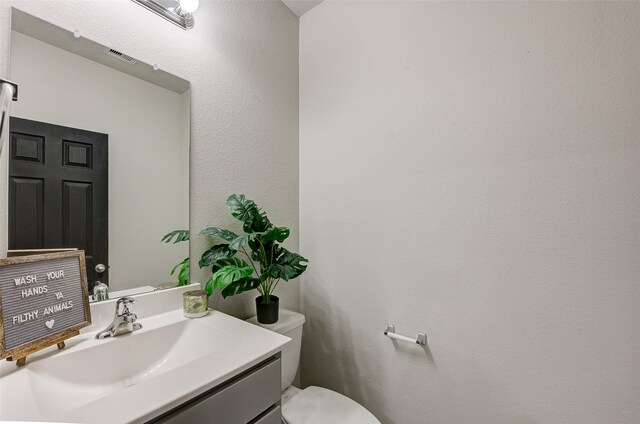 bathroom featuring toilet and vanity