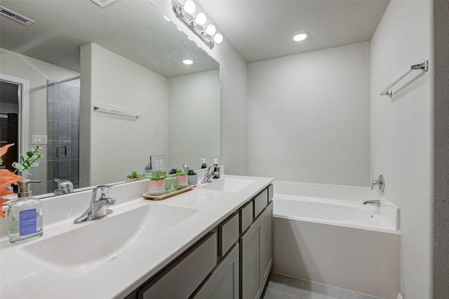 bathroom featuring vanity, a textured ceiling, tile patterned flooring, and plus walk in shower