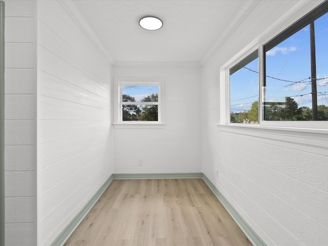 unfurnished room with crown molding and light wood-type flooring