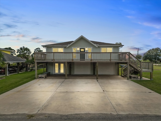 view of front of property featuring a deck, a yard, and a garage