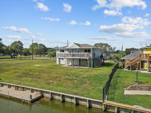 view of dock featuring a deck with water view and a yard