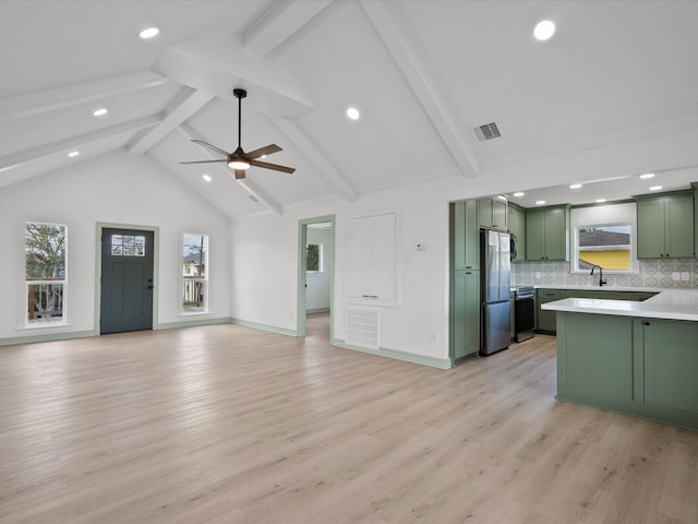 kitchen with stainless steel fridge, beam ceiling, backsplash, light hardwood / wood-style flooring, and green cabinets