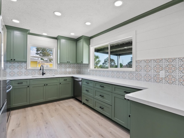 kitchen with light hardwood / wood-style flooring, green cabinets, crown molding, sink, and a textured ceiling