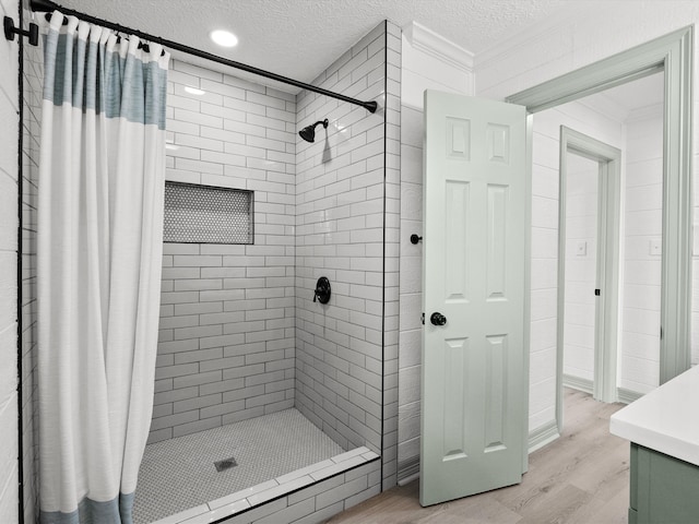 bathroom with hardwood / wood-style floors, a shower with curtain, and a textured ceiling