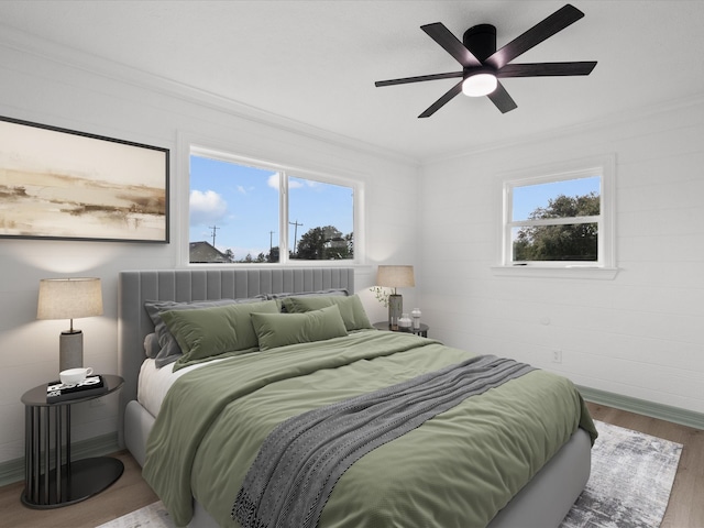 bedroom with multiple windows, ornamental molding, hardwood / wood-style flooring, and ceiling fan