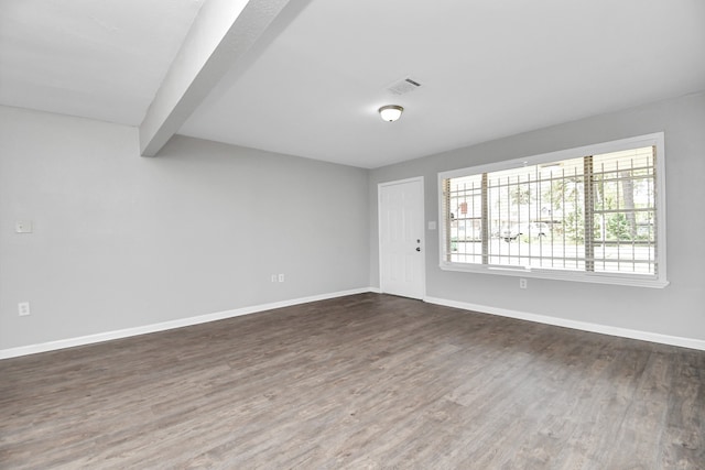 unfurnished room with dark hardwood / wood-style floors and beamed ceiling