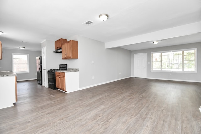 kitchen with black range with gas stovetop, sink, dark wood-type flooring, and stainless steel refrigerator