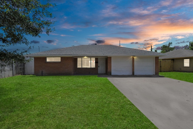 ranch-style house with a yard and a garage