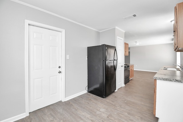 kitchen with ornamental molding, black appliances, sink, and light wood-type flooring