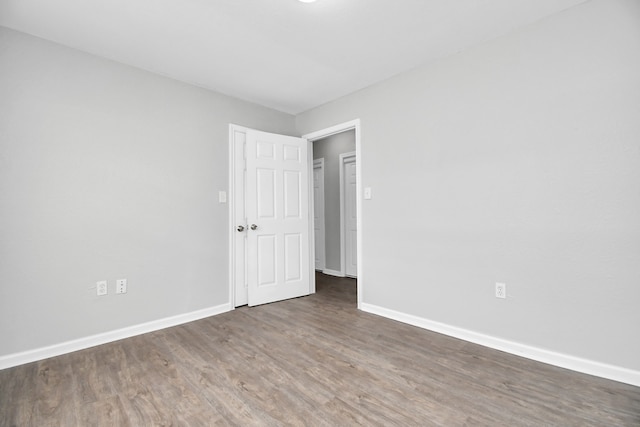 empty room with dark hardwood / wood-style flooring