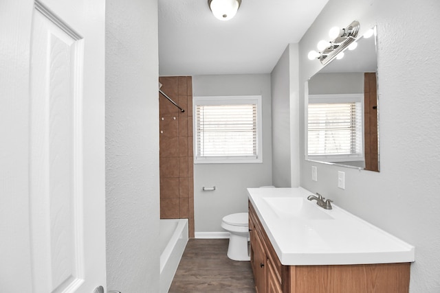 full bathroom with vanity, toilet, hardwood / wood-style flooring, and a wealth of natural light