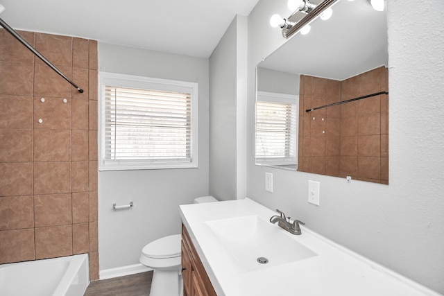 full bathroom featuring toilet, vanity, wood-type flooring, and a wealth of natural light