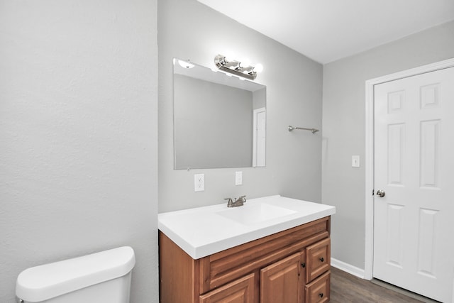 bathroom with vanity, wood-type flooring, and toilet