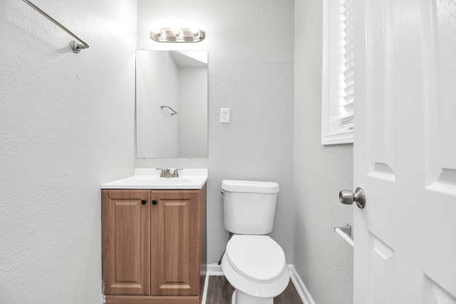 bathroom with vanity, toilet, and wood-type flooring