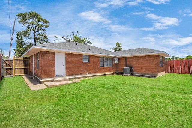 back of property with a yard and central air condition unit