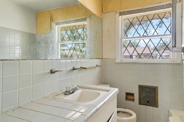 bathroom with tile walls, vanity, and toilet