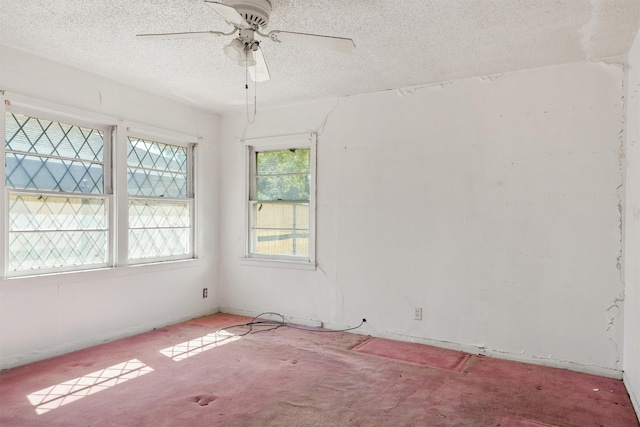 empty room with a textured ceiling, light colored carpet, and ceiling fan