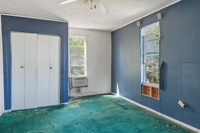 unfurnished bedroom featuring a closet, cooling unit, a textured ceiling, carpet flooring, and ceiling fan