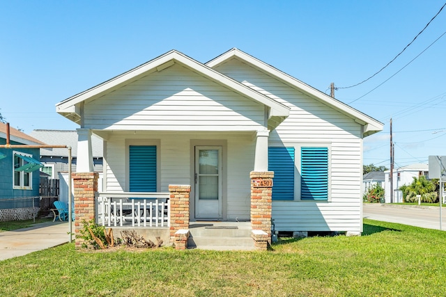 bungalow with a front yard and a porch