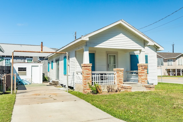 bungalow with a storage shed, a front yard, and a porch