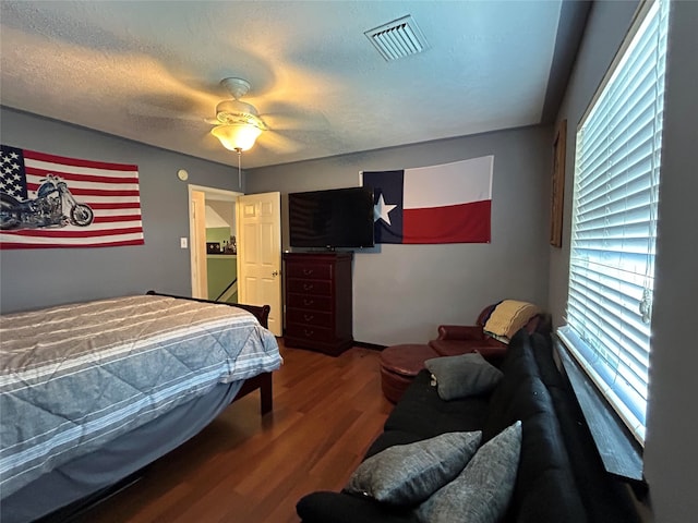 bedroom with ceiling fan, wood-type flooring, and a textured ceiling