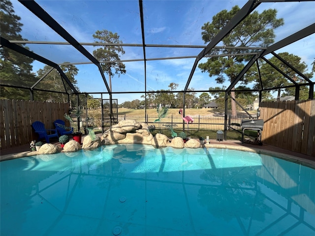 view of pool with a grill and glass enclosure