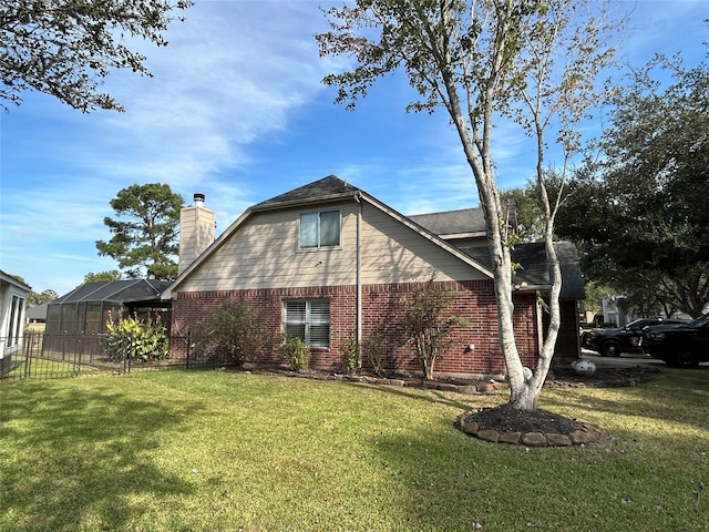 view of property exterior with a yard and glass enclosure