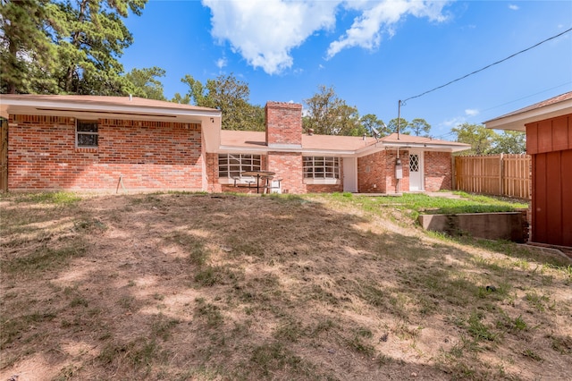 back of property featuring a lawn