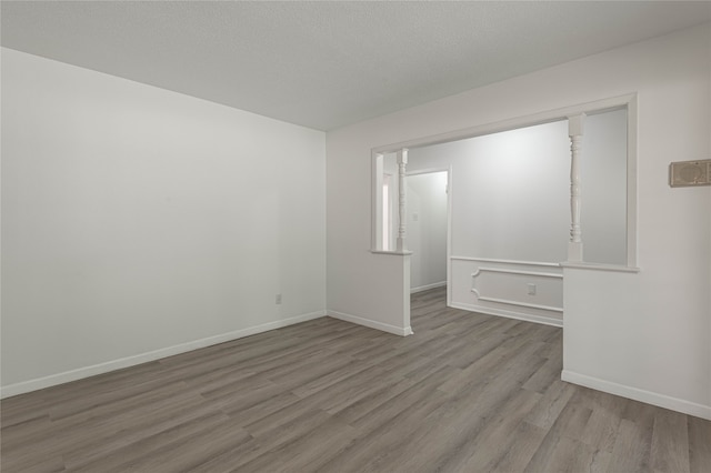 unfurnished bedroom with a textured ceiling and light hardwood / wood-style flooring