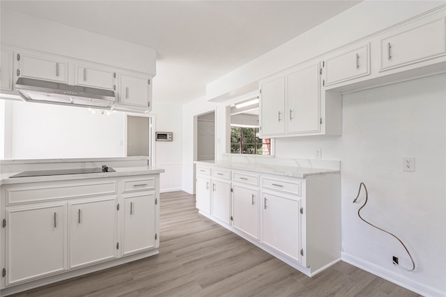 kitchen with black electric cooktop, white cabinetry, and light wood-type flooring