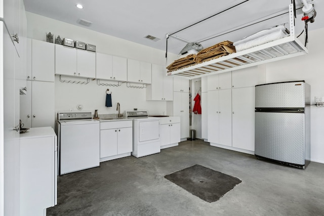 garage featuring sink, washer and dryer, and fridge