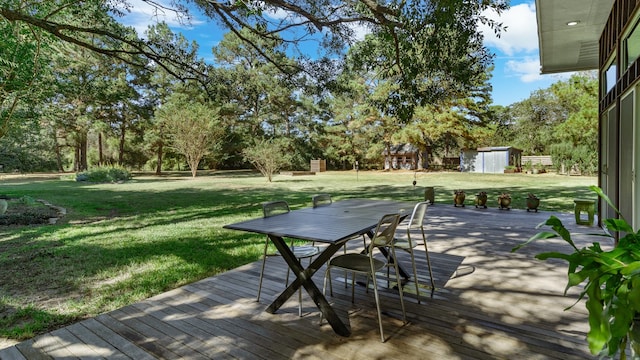 wooden terrace featuring a storage unit and a yard