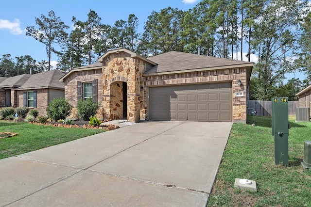 view of front of house with a front yard, a garage, and central air condition unit