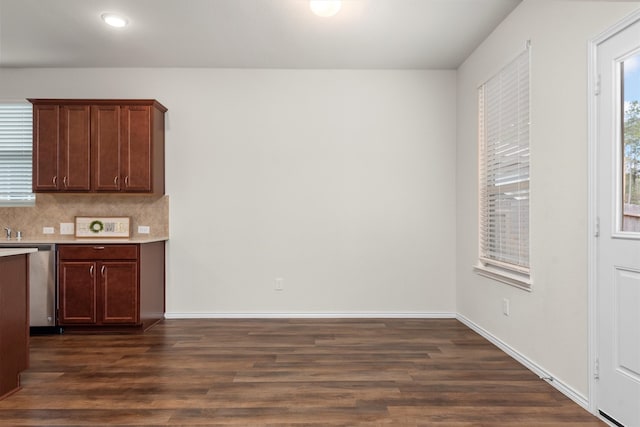 kitchen featuring stainless steel dishwasher, dark wood-type flooring, and backsplash