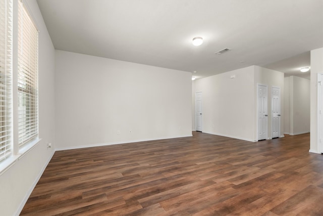 unfurnished room featuring dark wood-type flooring