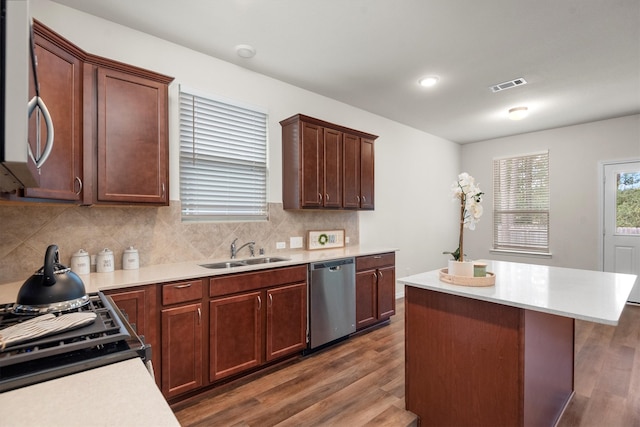 kitchen featuring stainless steel appliances, sink, backsplash, and dark hardwood / wood-style flooring